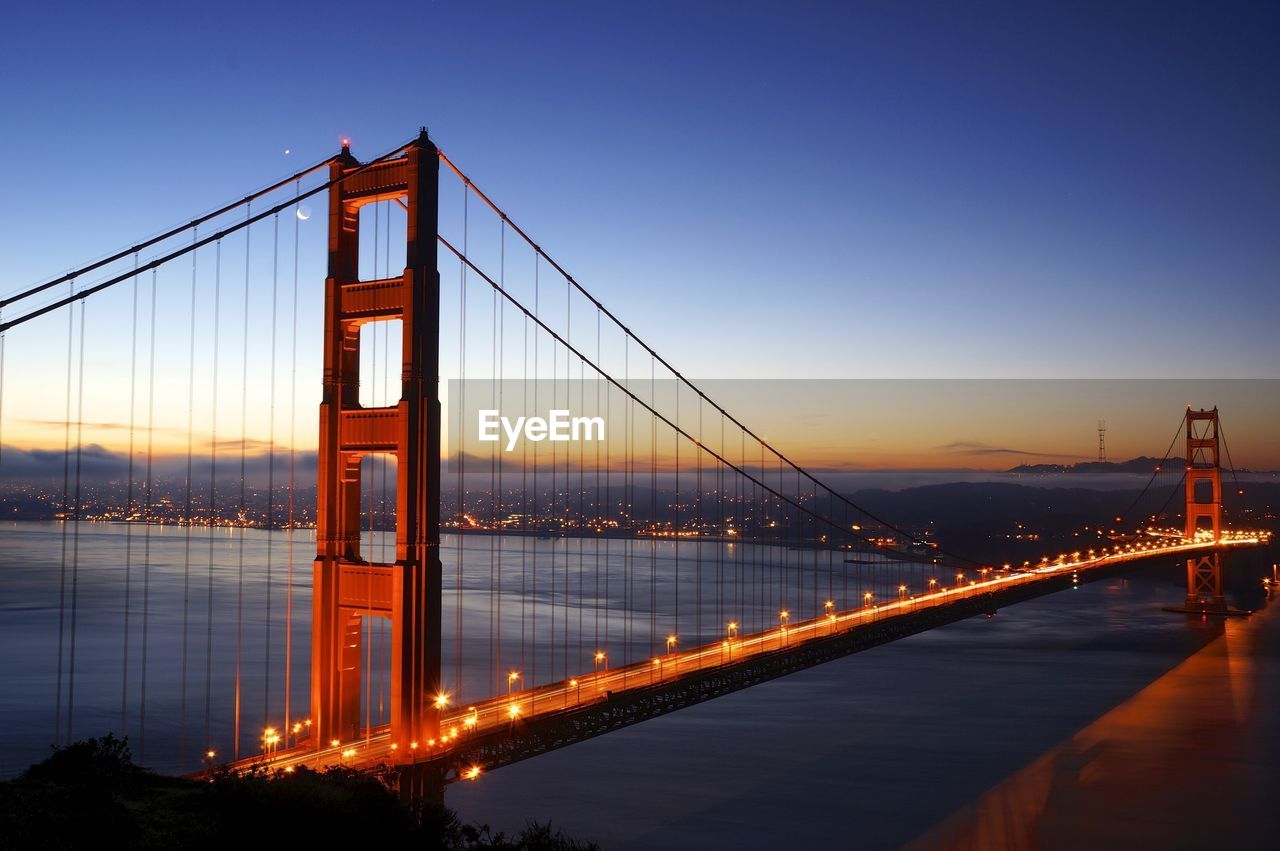 Golden gate bridge over sea against sky during sunset