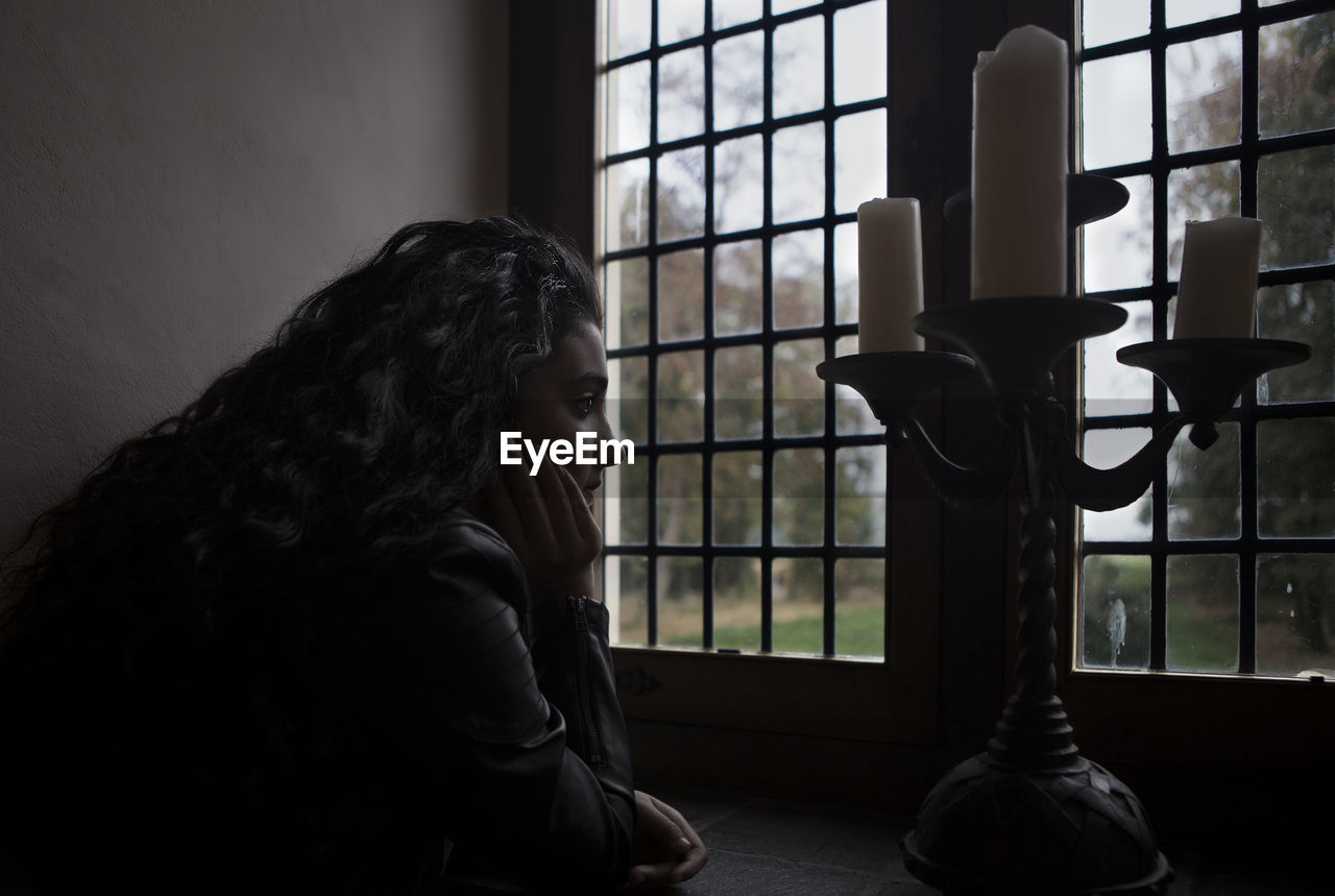 Close-up of teenage girl looking through window