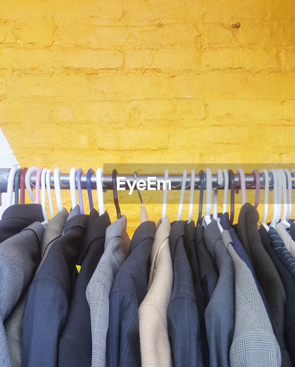 CLOSE-UP OF CLOTHES HANGING ON YELLOW PAPER