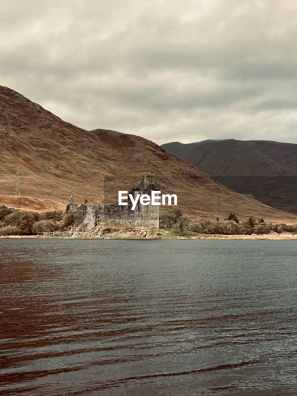 Lake and abandoned architecture against mountains