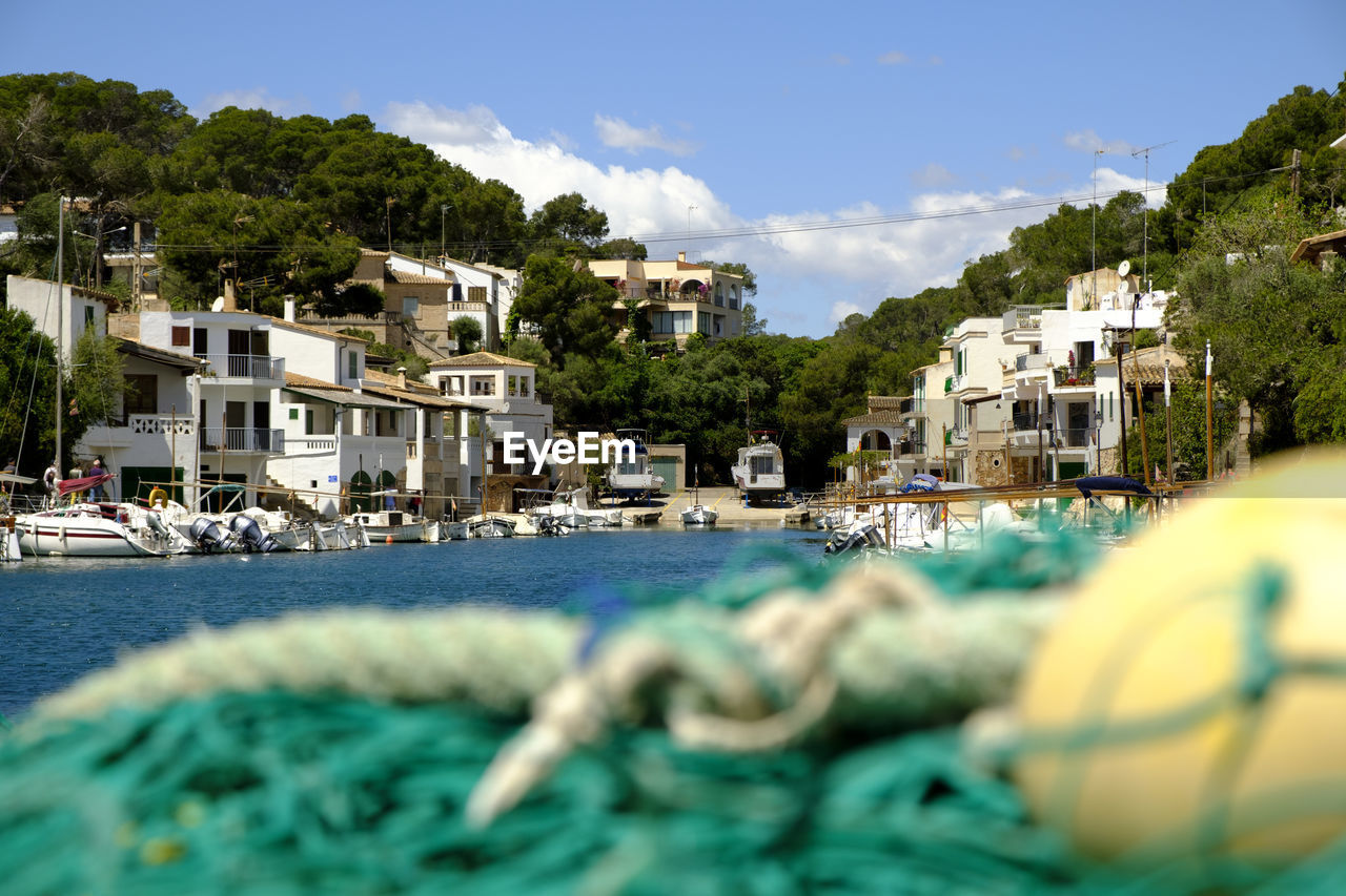 Sea by buildings against sky