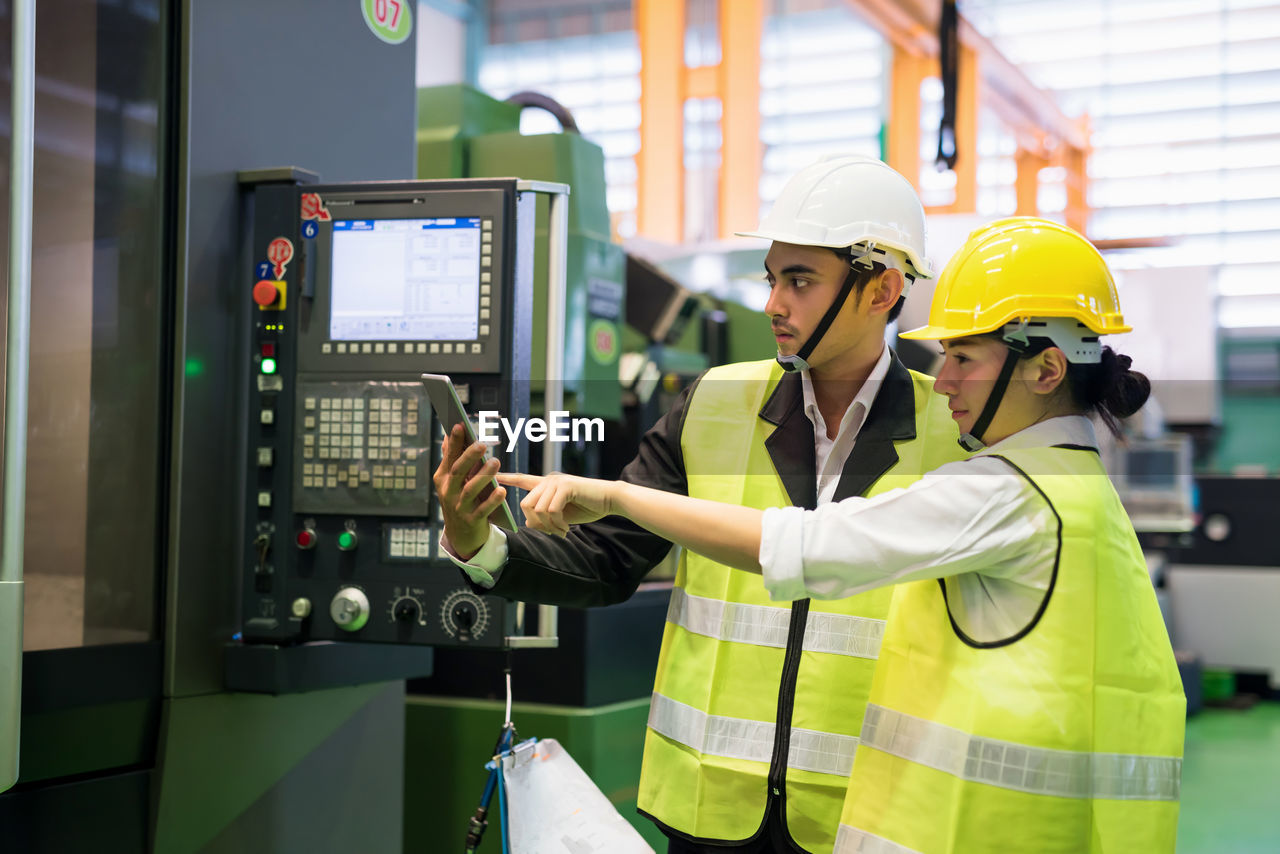 Side view of engineers working at factory