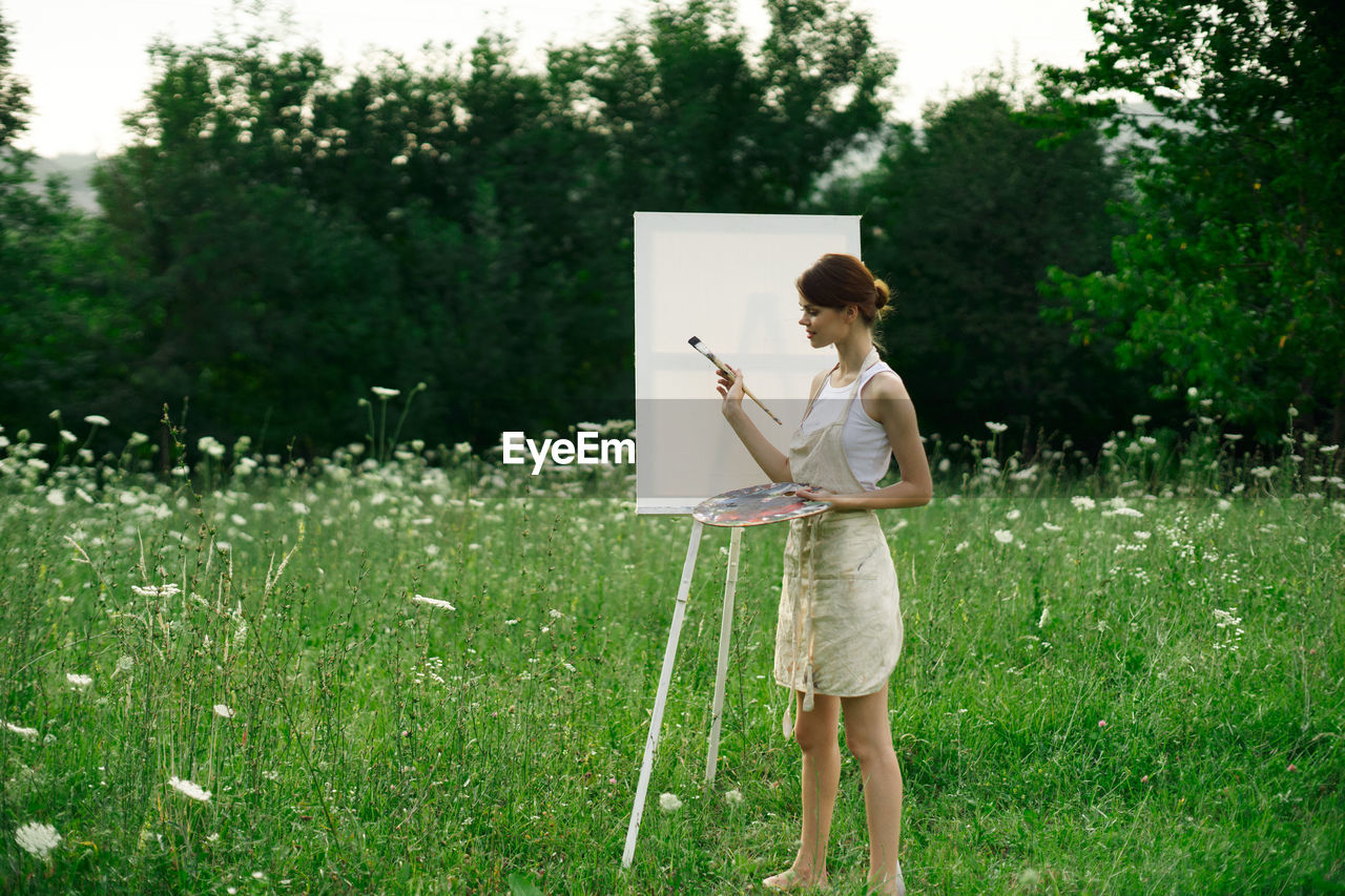 FULL LENGTH OF WOMAN STANDING ON FIELD