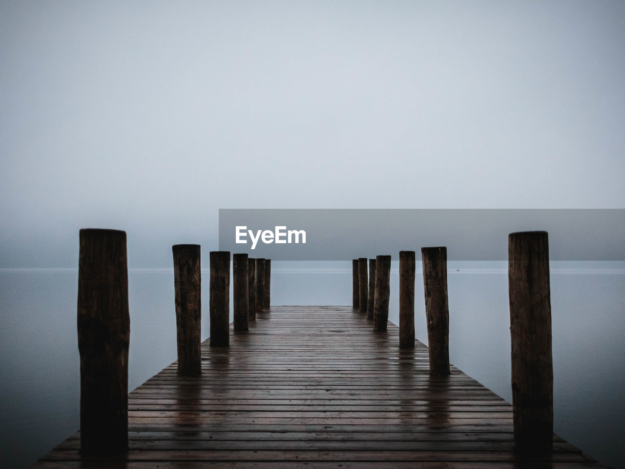 Wooden pier on sea against sky