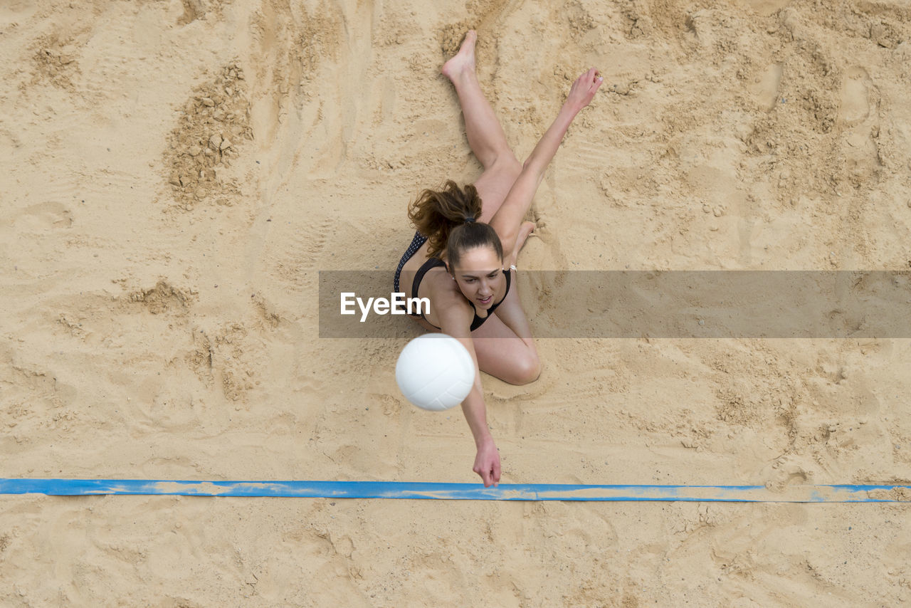 Woman with arms raised on beach