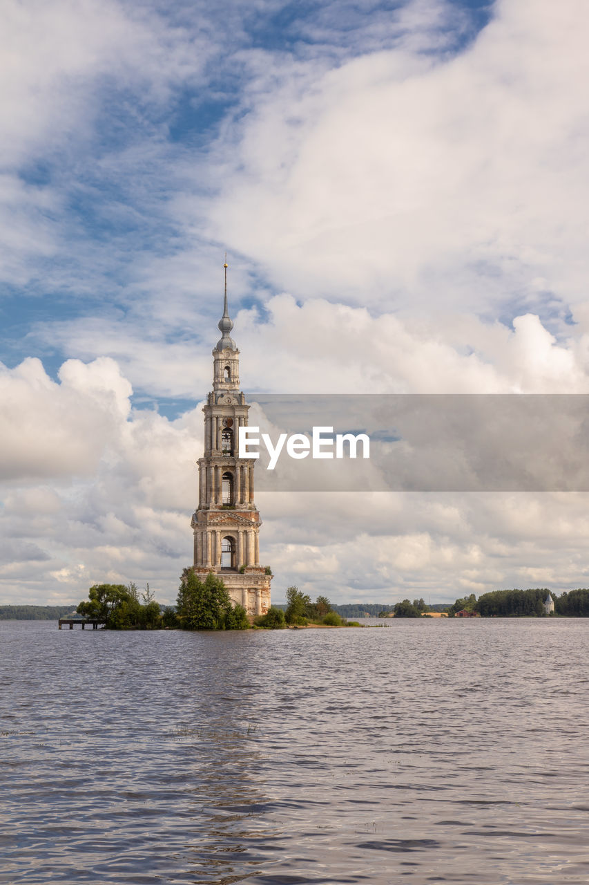 VIEW OF BUILDING BY RIVER AGAINST SKY