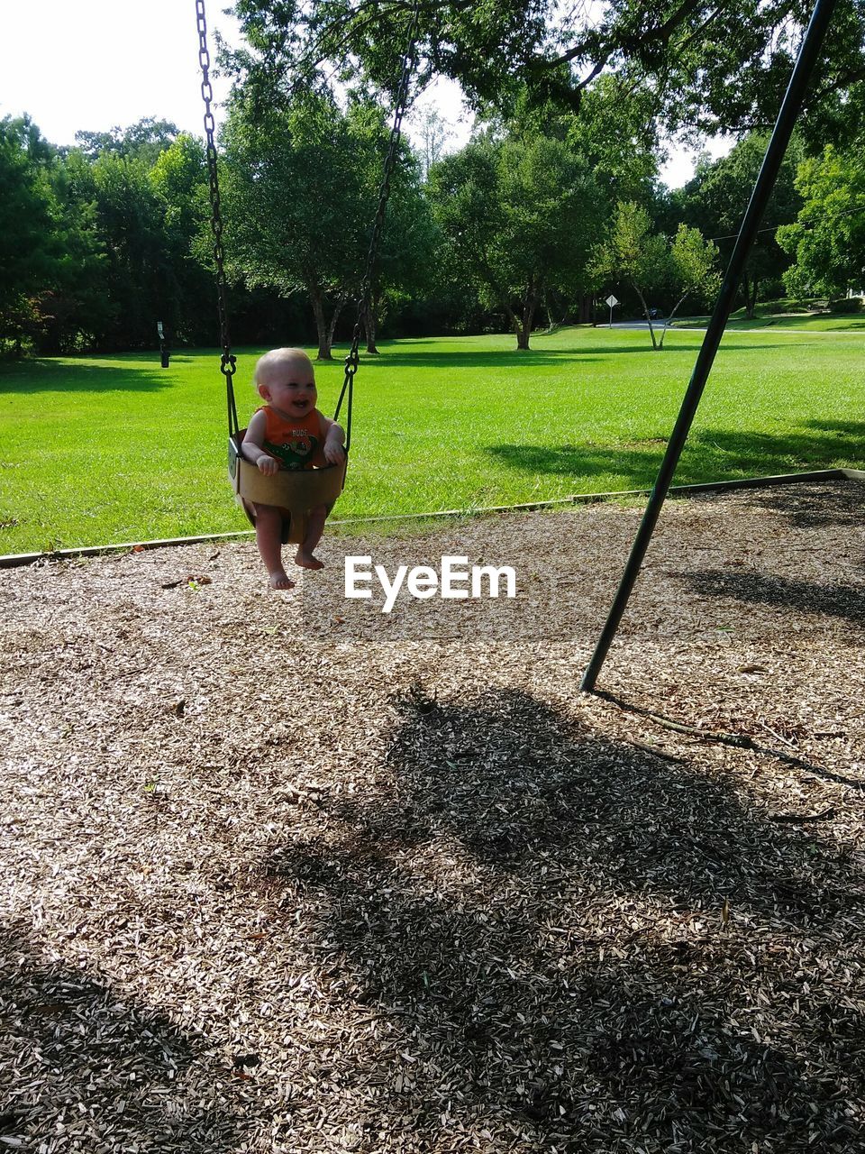 BOY PLAYING ON SWING AT PARK