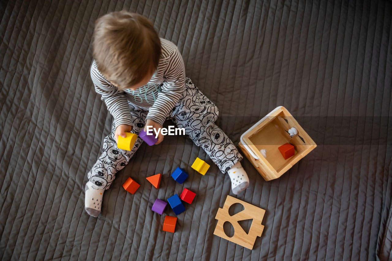 Directly above shot of boy with down syndrome playing on rug