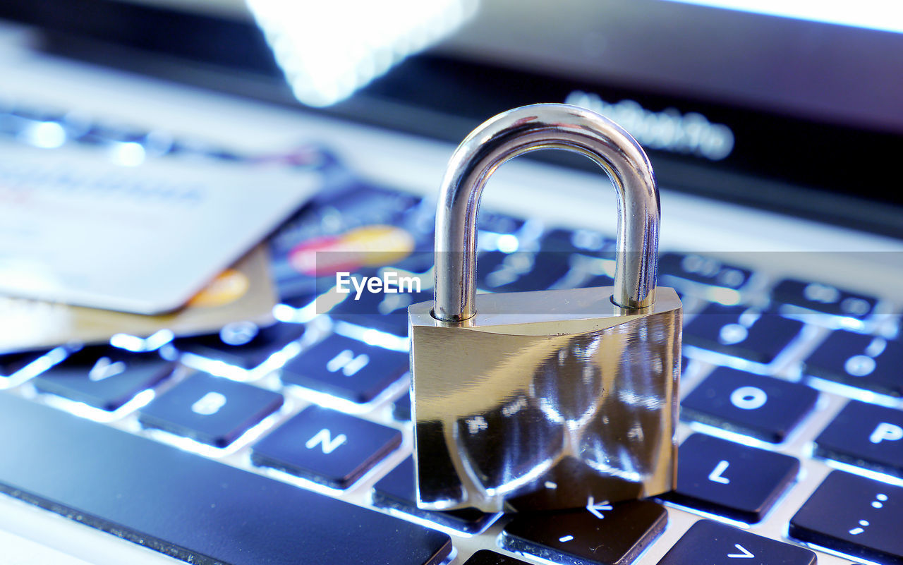 Close-up of lock with credit on laptop