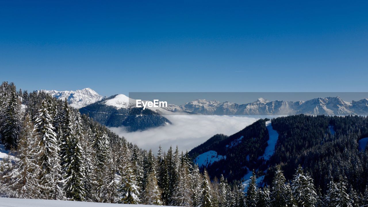 Scenic view of snowcapped mountain against blue sky