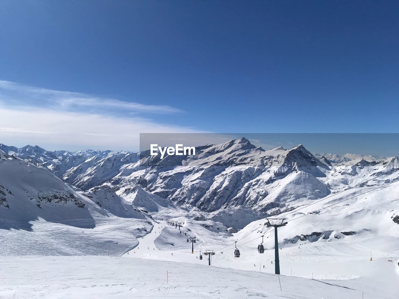 Scenic view of snowcapped mountains against blue sky