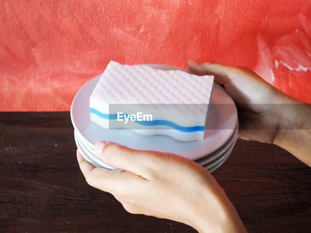 HIGH ANGLE VIEW OF PERSON HAND HOLDING BREAD ON TABLE