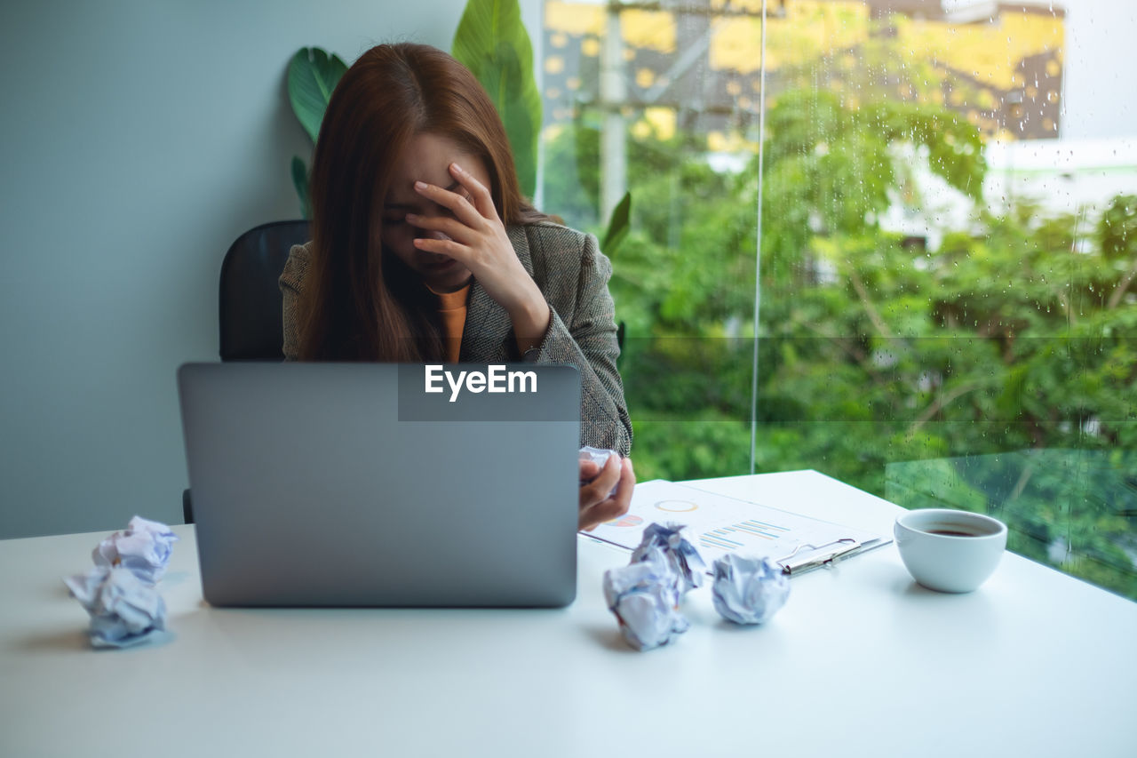 midsection of woman using laptop on table