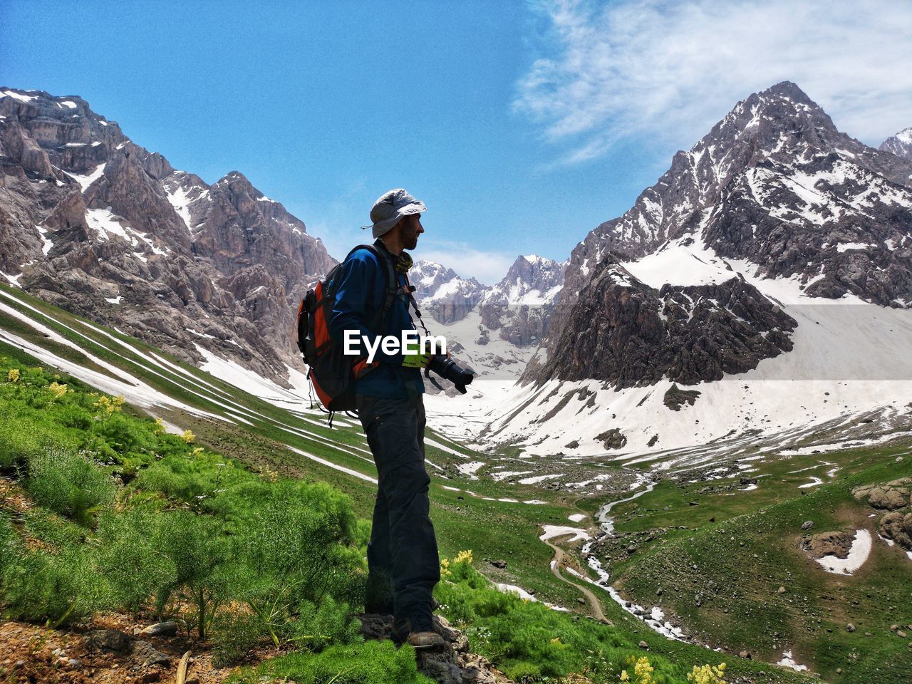 Man standing on snowcapped mountain against sky