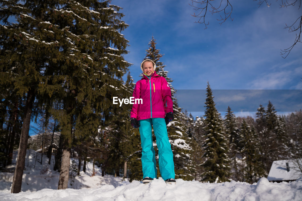 Portrait of child standing on snow covered land