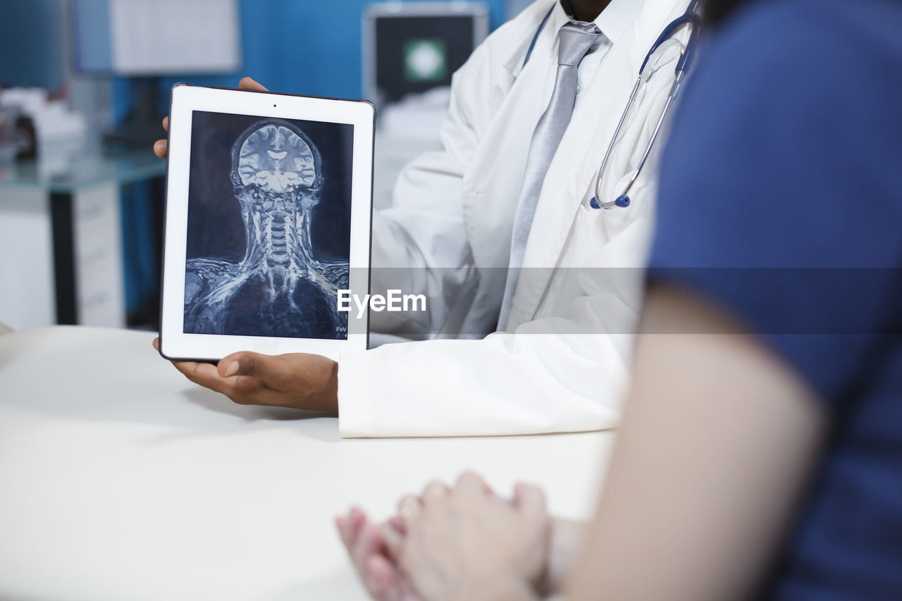 midsection of woman using mobile phone on table