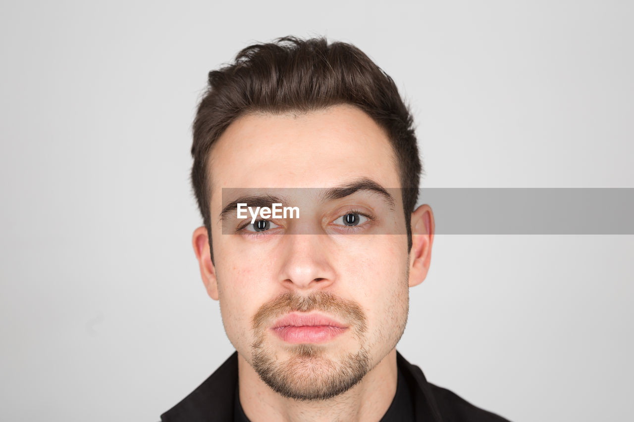 PORTRAIT OF MAN AGAINST WHITE BACKGROUND