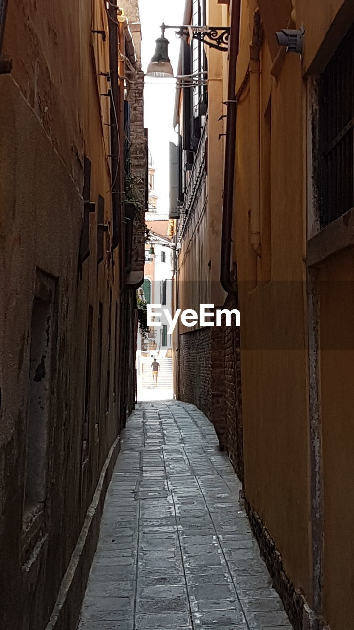 Alley amidst buildings against sky