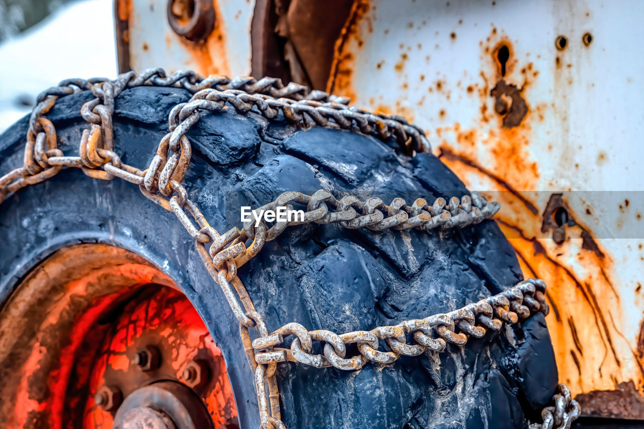 CLOSE-UP OF RUSTY CHAIN AGAINST BLUE SKY