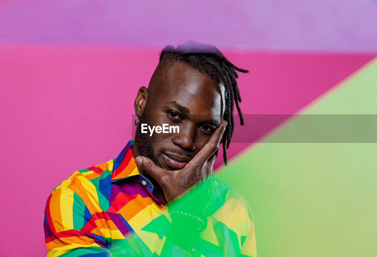 Portrait of young man against multi colored background