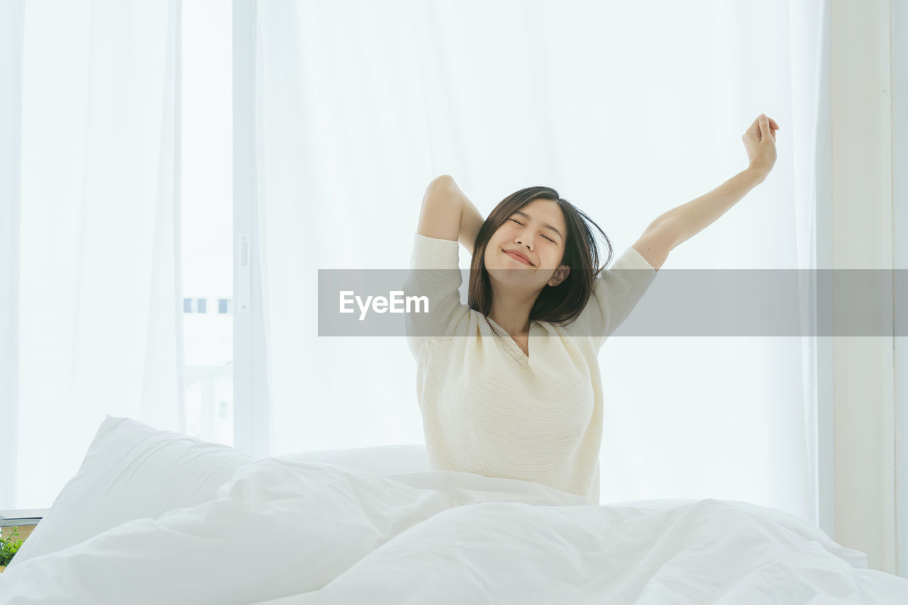 Lazy young woman relaxing on bed at home