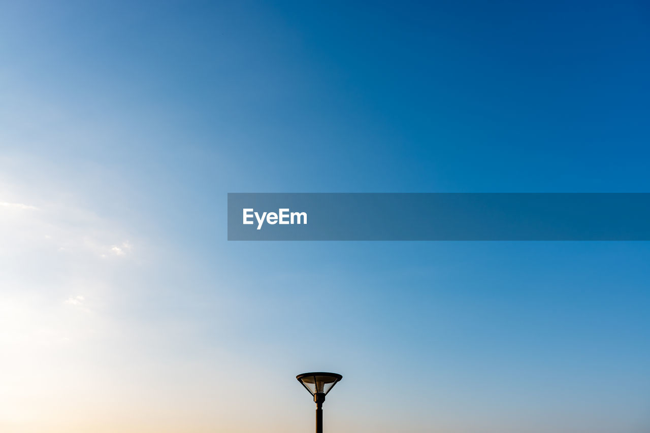 Low angle view of street light against blue sky