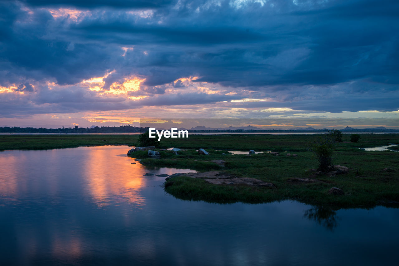 Scenic view of lake against dramatic sky during sunset, arugam bay, sri lanka