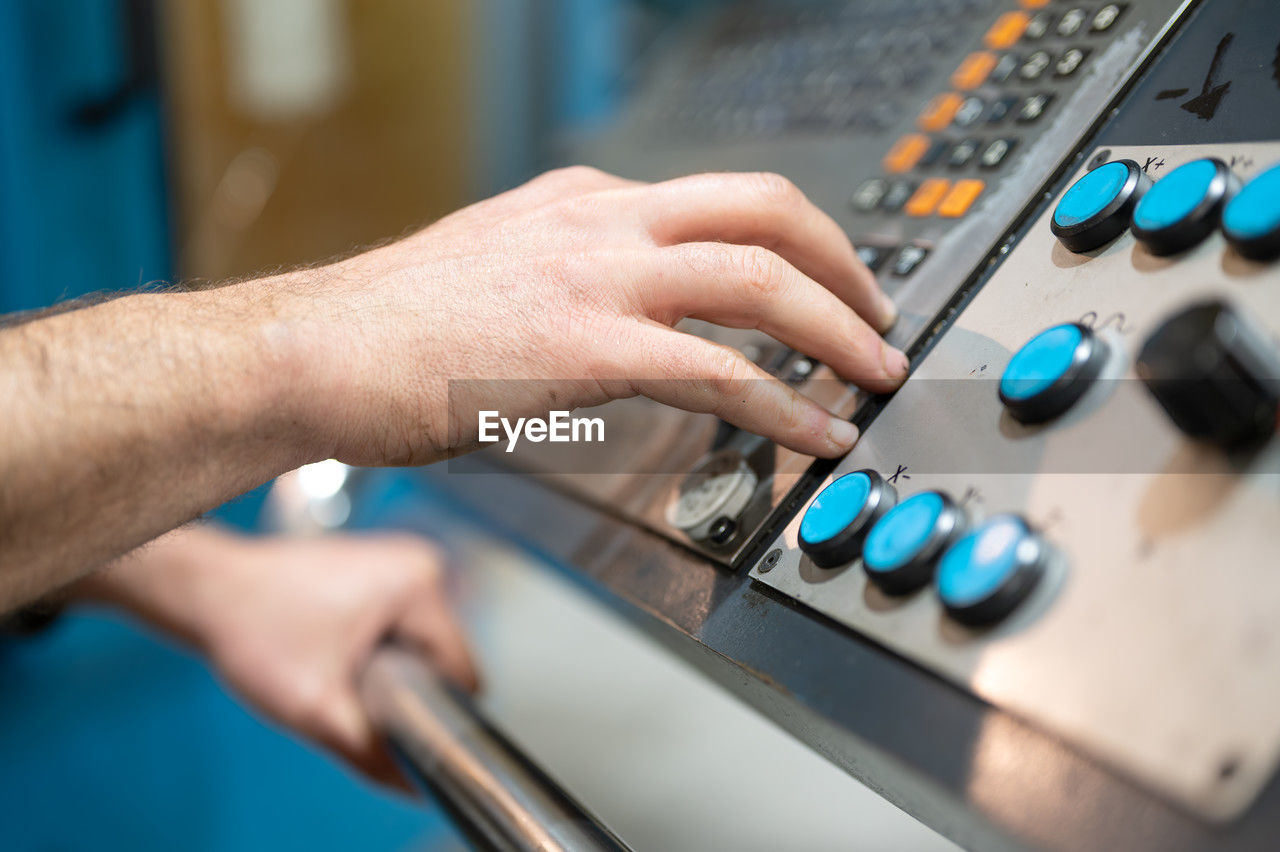 hand, technology, control, adult, one person, close-up, control panel, indoors, occupation, working, industry, skill, men, equipment, mixing console, expertise, selective focus, push button, adjusting