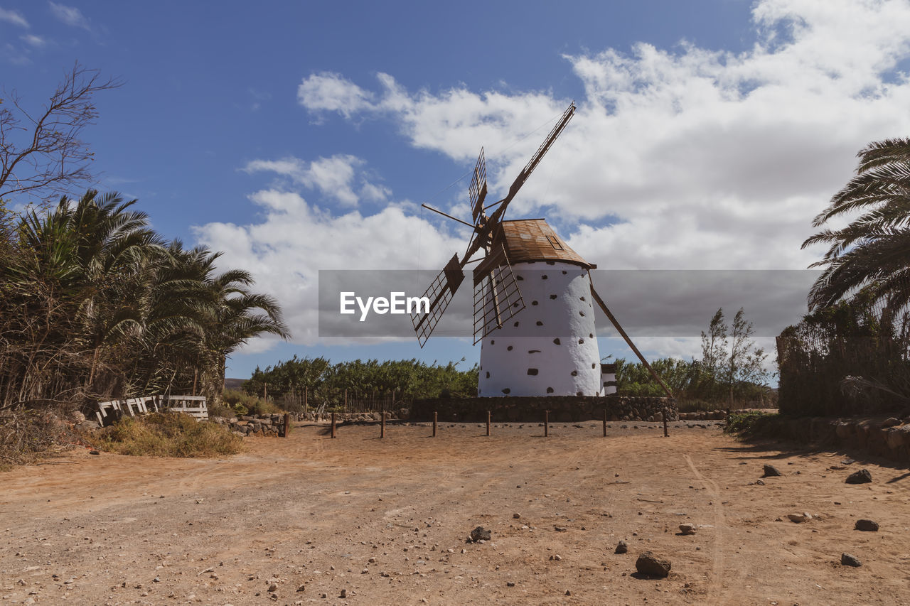 Traditional windmill on field against sky