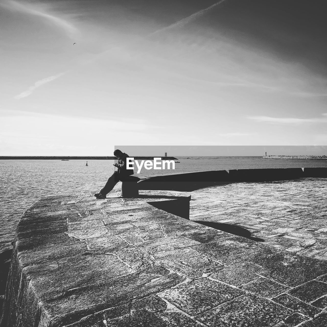 MAN STANDING ON SEA AGAINST SKY