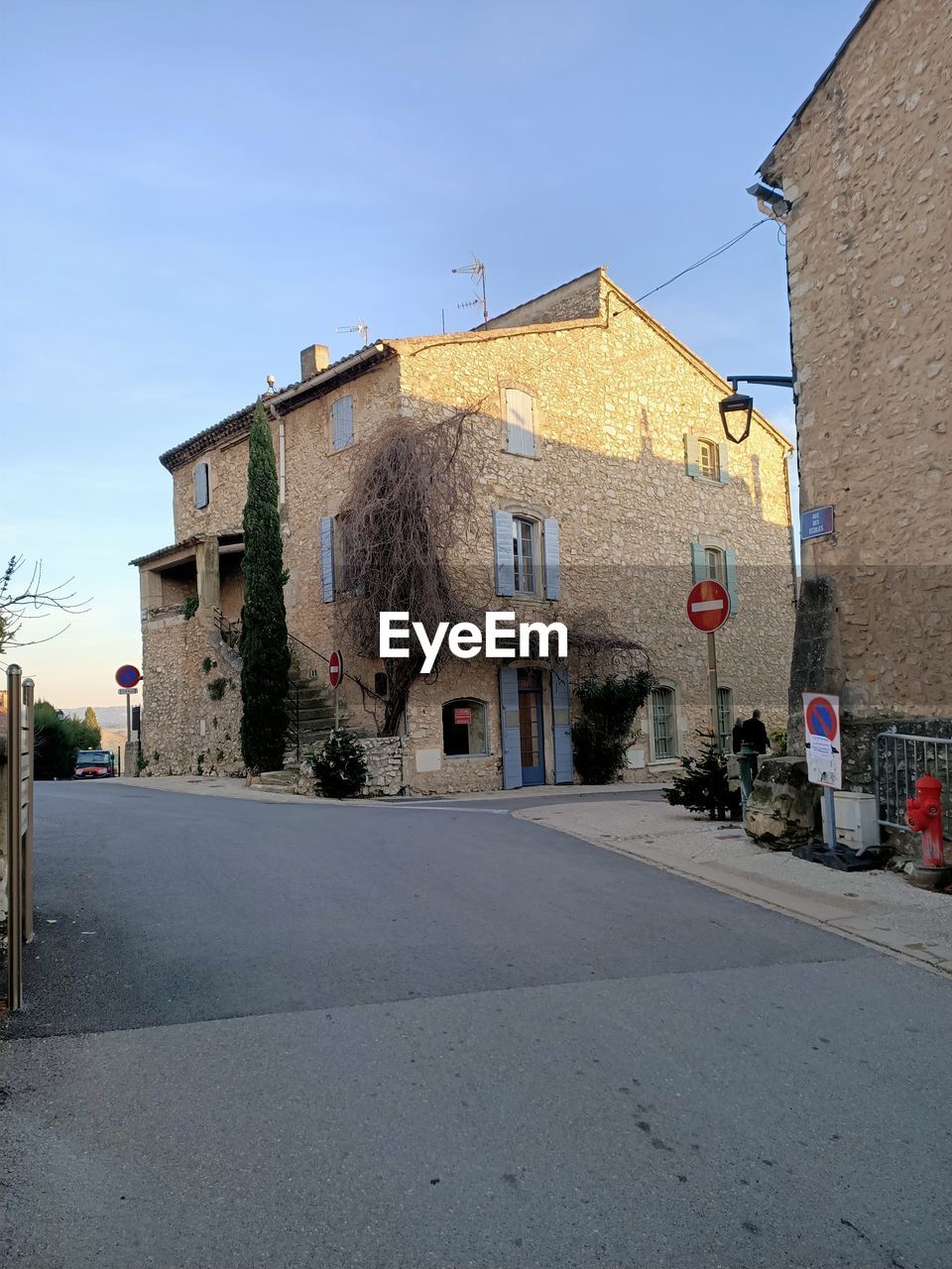 STREET AMIDST BUILDINGS IN CITY AGAINST CLEAR SKY