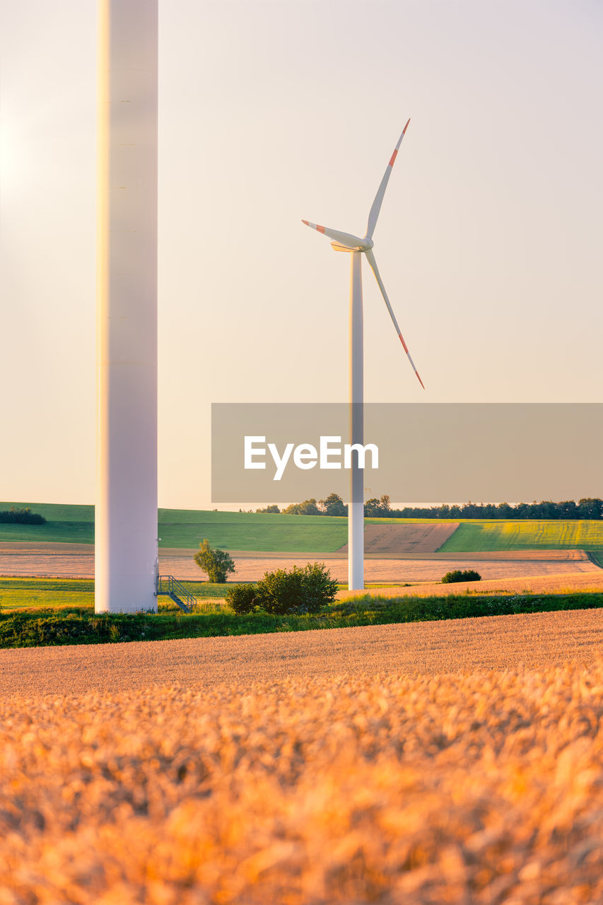 Wind turbine / windmill creating green energy. warm colors.