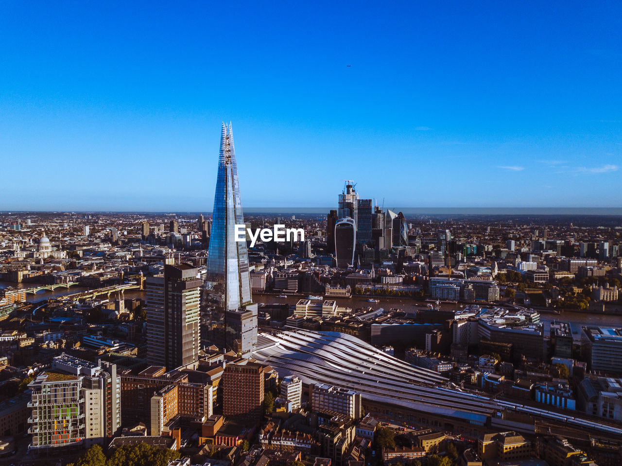 High angle view of city buildings against blue sky