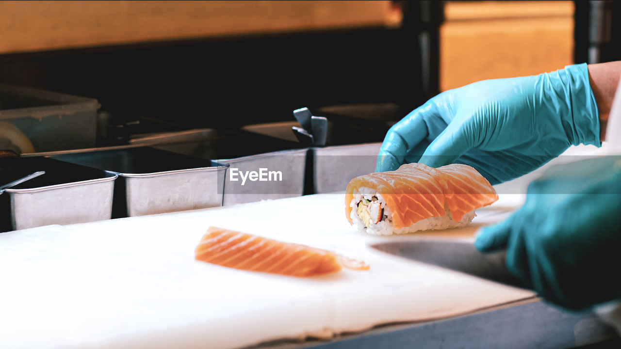 Chef holding salmon on kitchen knife in restaurant