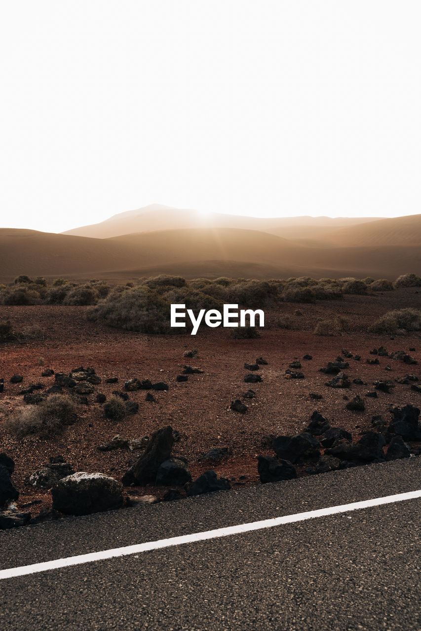 Driving through a volcanic landscape at sunset in lanzarote, spain