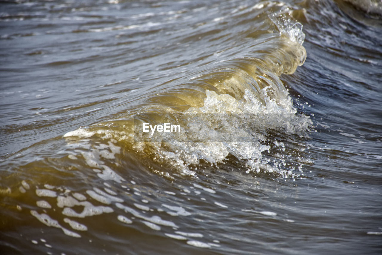 HIGH ANGLE VIEW OF WAVE SPLASHING ON SEA