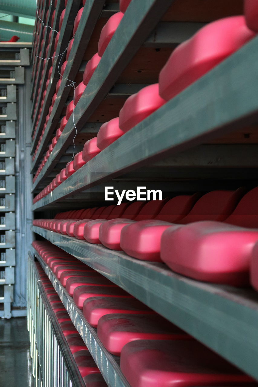 Close-up of stack of seats of retractable stand in gymnasium