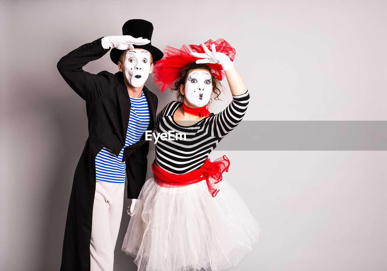 Portrait of young couple standing against red background