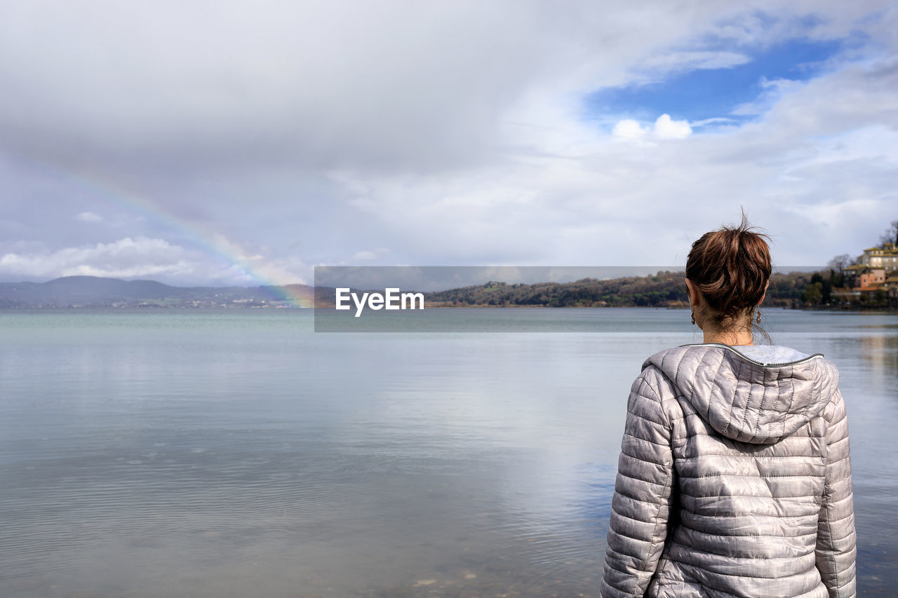 Rear view of woman looking at view of sea against sky