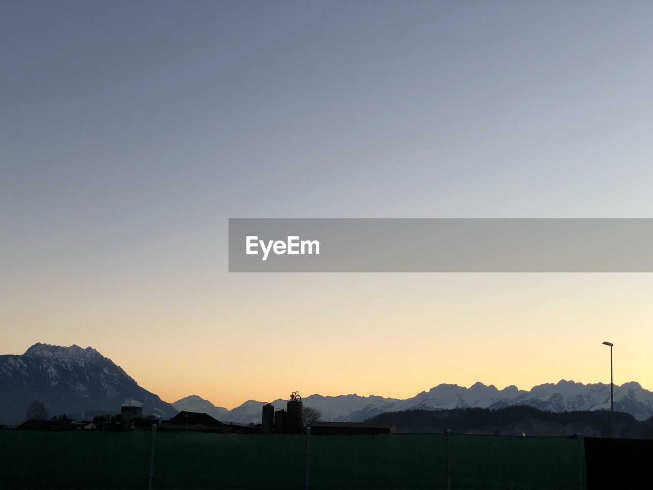 Scenic view of silhouette mountains against clear sky during sunset