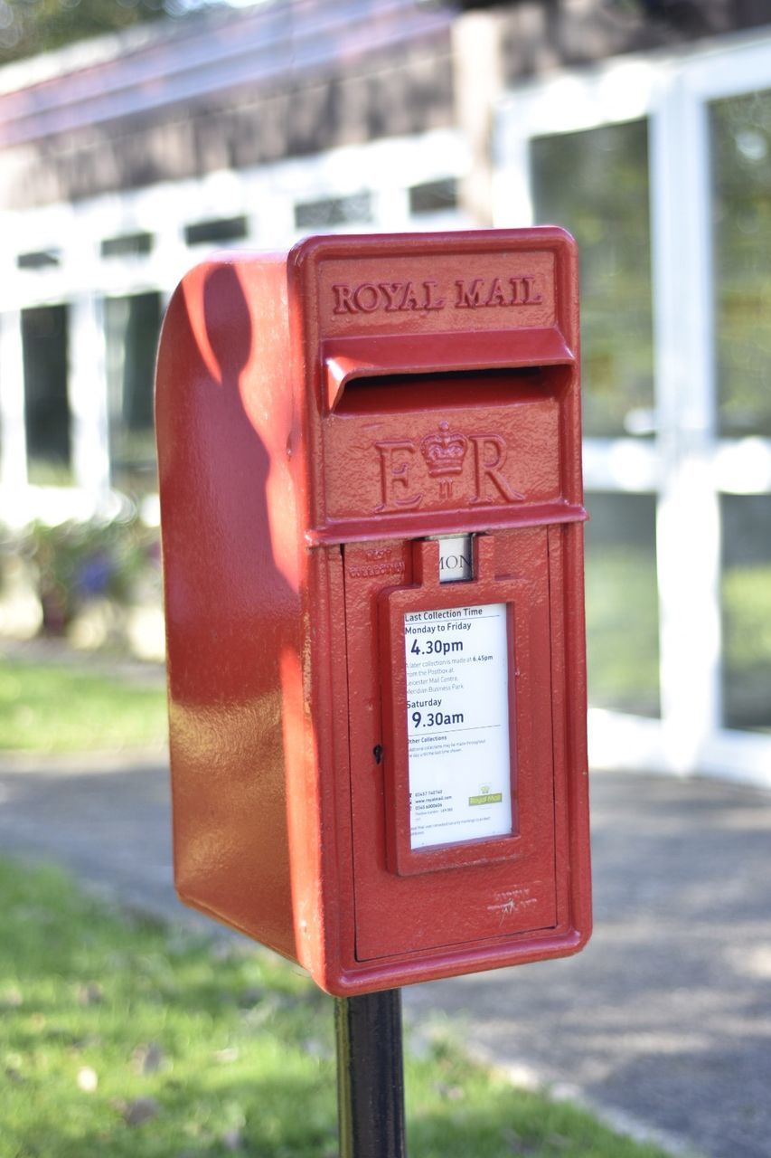 CLOSE-UP OF RED MAILBOX ON THE WALL