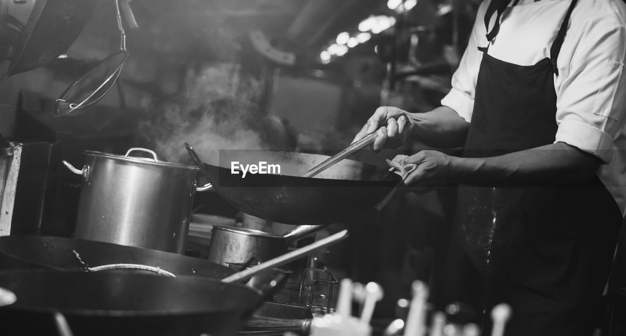 Chef stir fry busy cooking in kitchen. chef stir fry the food in a frying pan, 