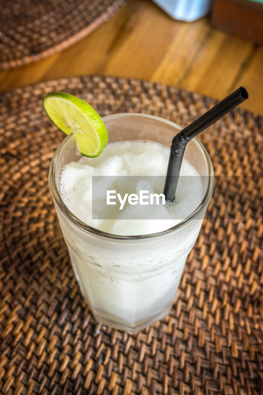 A glass with fresh organic lime juice on a wooden background. bali island.