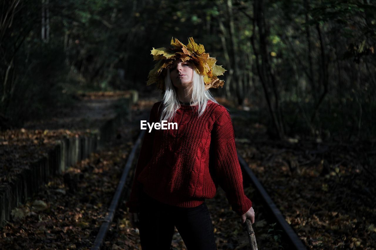 MIDSECTION OF WOMAN STANDING IN FOREST