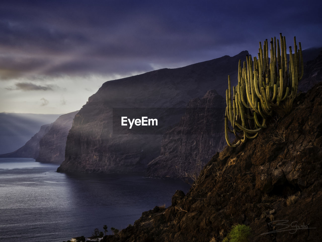 Scenic view of sea and mountains against sky