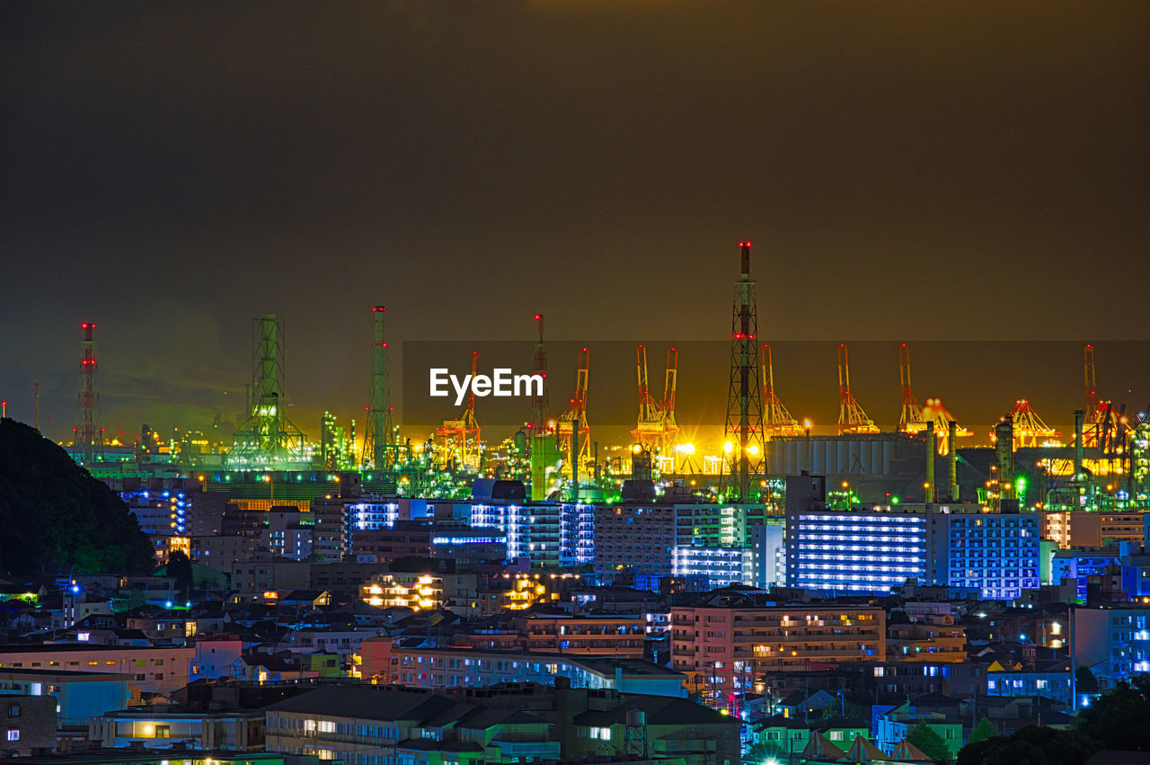 Illuminated city against sky at night