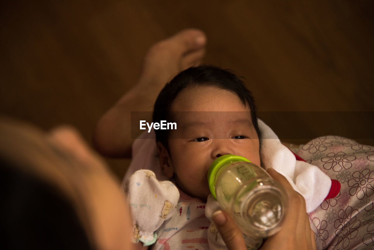 Cropped hand of person feeding baby