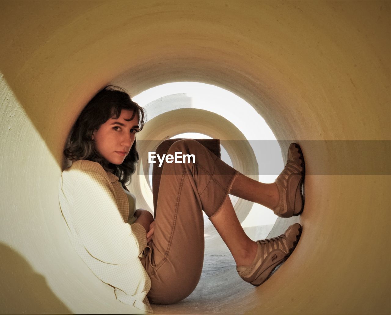Portrait of woman sitting in concrete tube