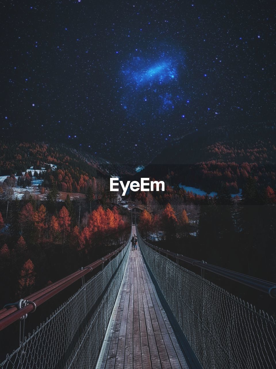 Footbridge against sky at night