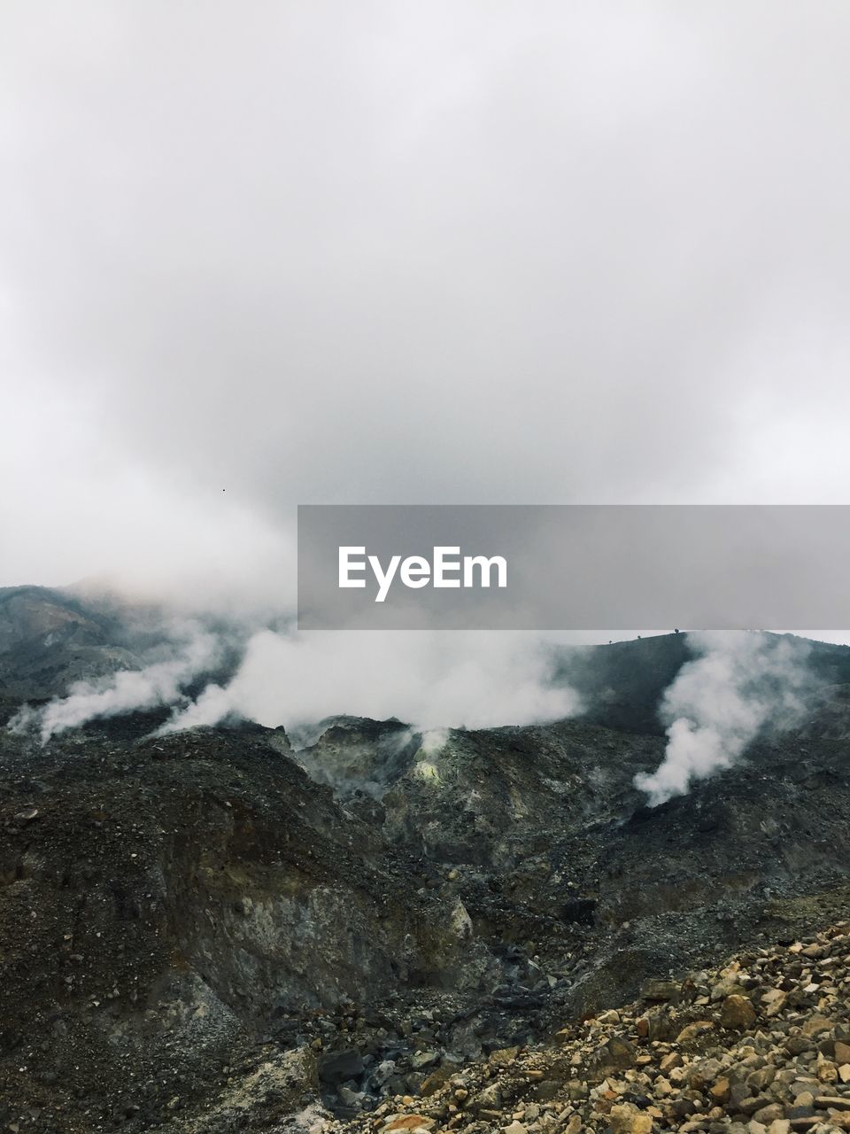 SMOKE EMITTING FROM MOUNTAIN AGAINST SKY